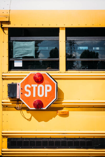 вид сбоку на школьный автобус со знаком остановки
