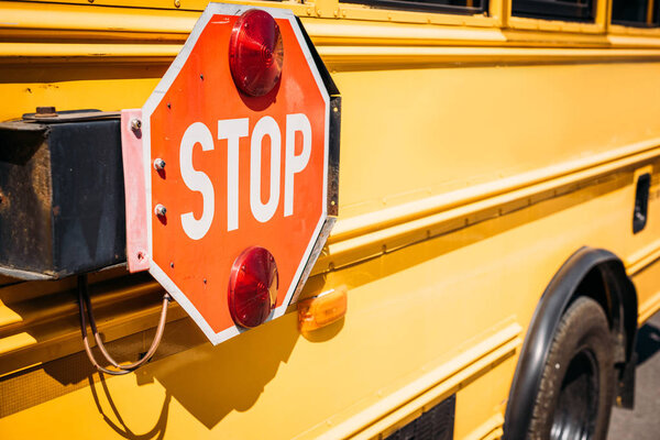 частичный вид школьного автобуса со знаком "Стоп"
