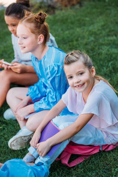 一緒に芝生の上に座っているかわいい女子中学生のグループ — ストック写真