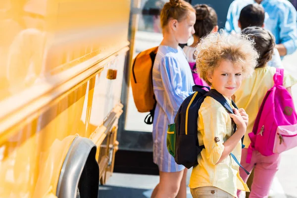 Adorable Curly Schoolboy His Classmates Standing School Bus Stock Picture