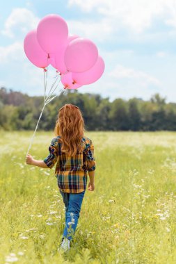 arkadan görünüşü çocuk pembe balonlu yaz alanına yürüyor