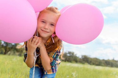 Kamera yaz alanına bakarak pembe balonlu şirin çocuk portresi