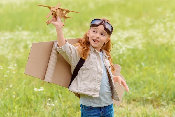 Portret Van Kindje Piloot Kostuum Met Houten Speelgoed Vliegtuig Staan — Gratis stockfoto