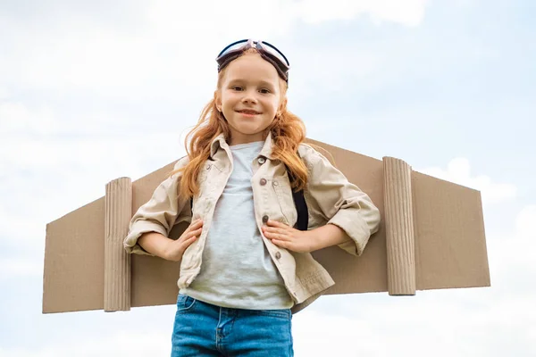 低角度的儿童与纸飞机机翼背面和防护眼镜头上的蓝色多云的天空 — 图库照片