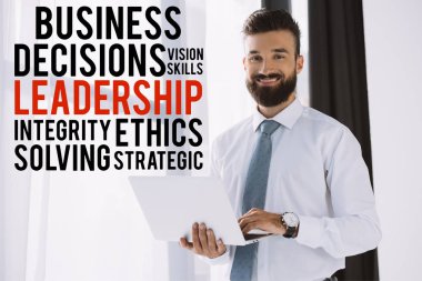 liderlik kavramı ile pencere yakınındaki dizüstü kullanarak sakallı gülümseyen iş adamı