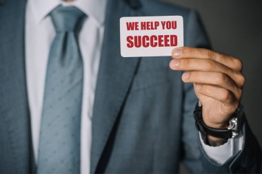 partial view of businessman showing card with 