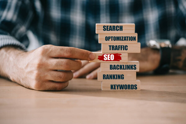 partial view of developer playing block wooden game with SEO ideas