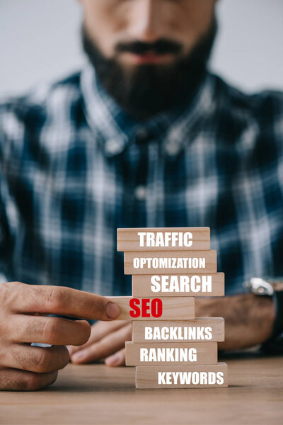 обрезанный вид разработчика, играющего с деревянными блоками башня игра с идеями SEO
