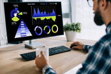 cropped shot of man with cup of coffee using computer with statistics charts on screen clipart