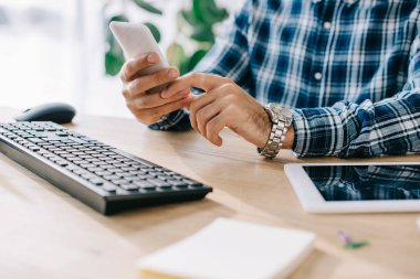 İşyerinde smartphone kullanarak işadamı kadeh kırpılmış