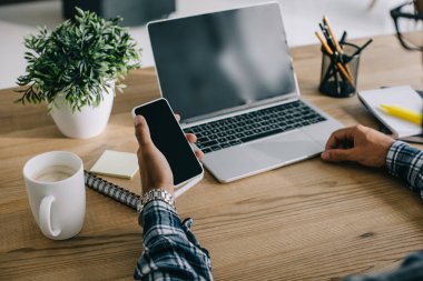 SEO profesyonel laptop ve smartphone işyerinde kullanarak kırpılmış atış