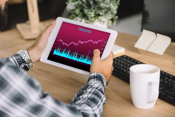 обрезанный снимок бизнесмена с помощью планшета с таблицей торговой статистики на рабочем месте

