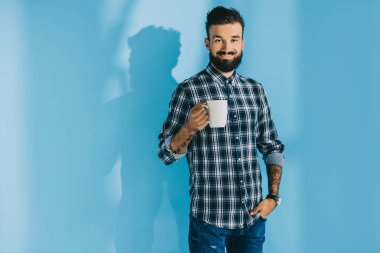 kahve, mavi tutan kareli gömlekli gülümseyen yakışıklı