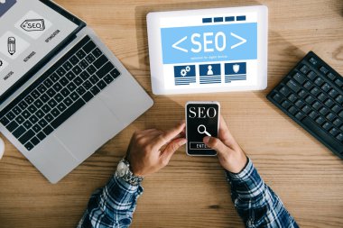 profesyonel seo Yöneticisi işyerinde dijital cihazlar kullanarak atış kırpılmış