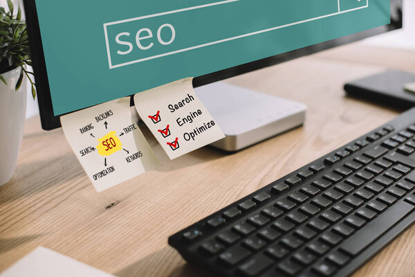 close-up shot of computer screen with SEO stickers and keyboard at modern workplace