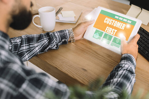 cropped shot of developer using tablet with "customer first" lettering