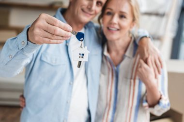close-up view of happy elderly couple holding keys from new nome during relocation clipart