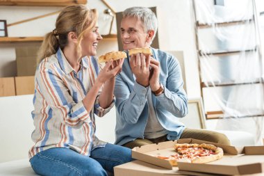 Pizza yemek ve diğer her yeni ev tehcir sırasında gülümseyen mutlu yaşlı çift