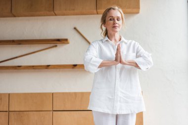 namaste hareketi sırasında pratik yoga gösterilen kapalı gözlerle sportif Olgun kadın