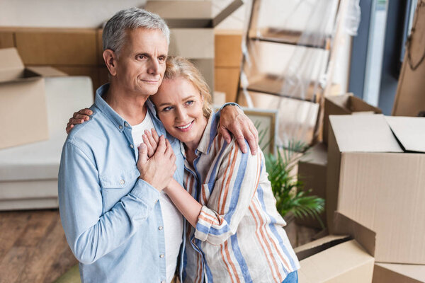high angle view of happy senior couple embracing and holding hands while moving home