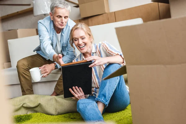 Glückliches Seniorenpaar Schaut Sich Fotoalbum Während Neuen Haus Zusammensitzt — Stockfoto