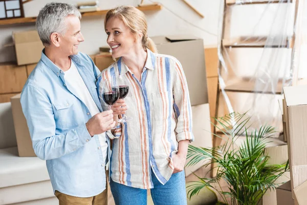 Gelukkige Senior Paar Glazen Wijn Houden Glimlachen Elkaar Tijdens Verhuizing — Stockfoto