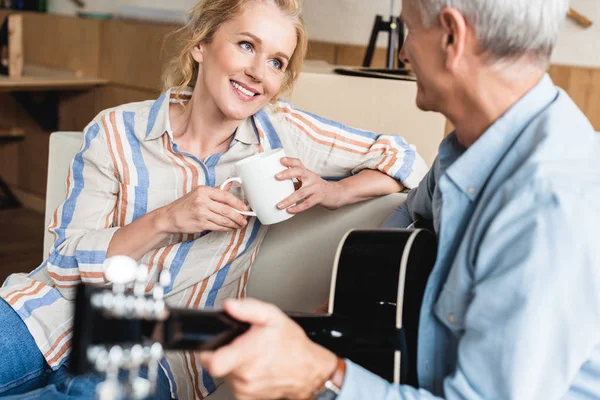 Anciana Sosteniendo Taza Mirando Marido Mayor Tocando Guitarra Nuevo Hogar —  Fotos de Stock