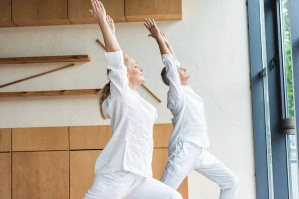 Sidovy Sportig Senior Par Utför Krigare Utgör Samtidigt Öva Yoga — Stockfoto