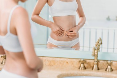 Genç kadın iç çamaşırı banyo aynaya bakarak kadeh kırpılmış