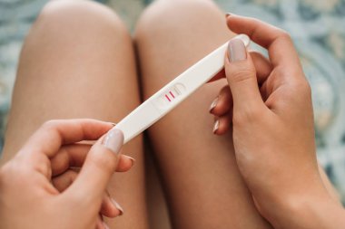 Hamilelik testi tutan genç kadın görüntüsünü kırpılmış