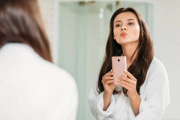 在浴室里用智能手机自拍的漂亮年轻女子的选择焦点 — 图库照片
