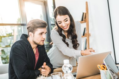 çok kültürlü genç iş adamları birlikte ofiste çalışırken dizüstü kullanarak portresi 