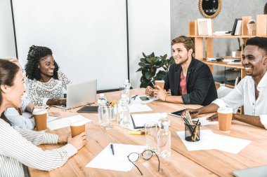çok kültürlü gülümseyen iş adamları office Semineri sırasında iş stratejisini tartışıyor