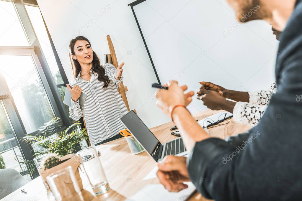 portrait of young asian businesswoman presenting business idea to colleagues during meeting