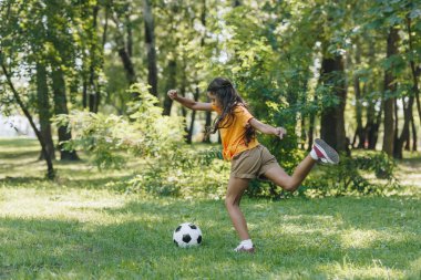Çocuk park futbol topu tekmeleme yan görünüm