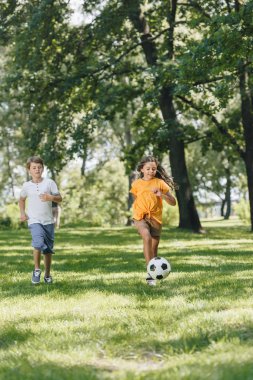 parkta futbol topuyla oynayan sevimli mutlu çocuklar 