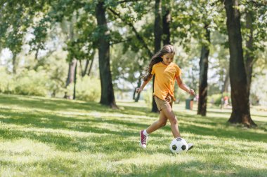 parkta futbol topuyla oynayan güzel mutlu çocuk 