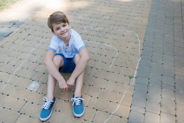 Kamera Park tebeşir ile çizerken gülümseyen sevimli çocuğun yüksek açılı görünüş