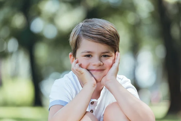 公園でカメラに笑顔かわいい幸せな男の子の肖像画 — ストック写真