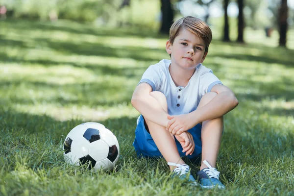 Милий Маленький Хлопчик Сидить Траві Футбольним Ячем Дивиться Камеру Парку — стокове фото