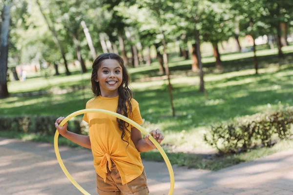 Lucu Bahagia Anak Memegang Hula Hoop Dan Tersenyum Kamera Taman — Foto Stok Gratis