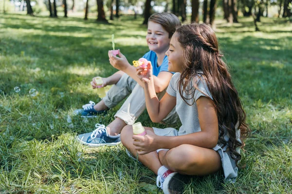 Vista Lateral Lindos Niños Sonrientes Soplando Burbujas Jabón Parque —  Fotos de Stock