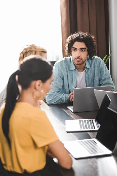 Jonge Zakenman Praten Met Vrouwelijke Partners Aan Tafel Met Laptops — Stockfoto