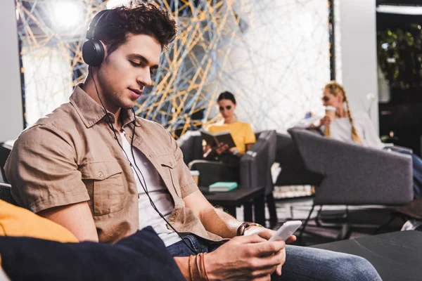 Jovem Empresário Fones Ouvido Usando Smartphone Escritório Coworking Moderno — Fotografia de Stock