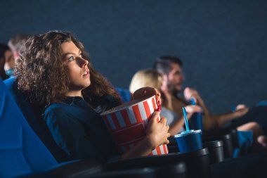 korkmuş kadın sinema film izlerken patlamış mısır ile yan görünüm