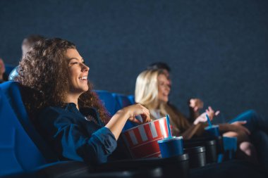 sinema film izlerken patlamış mısır ile neşeli kadın yan görünüm