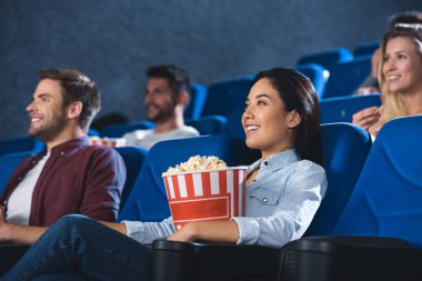 Asyalı kadın sinema yalnız film izlerken patlamış mısır ile gülümseyen