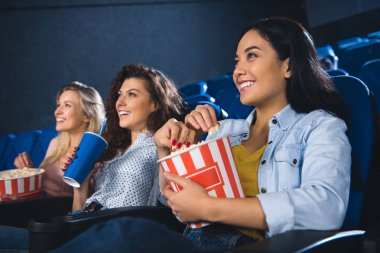patlamış mısır izlerken filmde birlikte sinema salonu çok ırklı kadınlarla gülümseyen