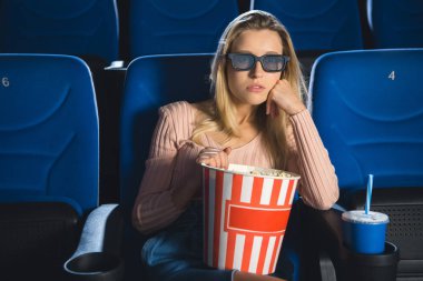 film sinemada yalnız izlerken patlamış mısır ile 3d gözlük odaklı kadın portresi