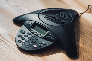 Ofis ahşap masa üzerinde konferans telefon yakın çekim vurdu